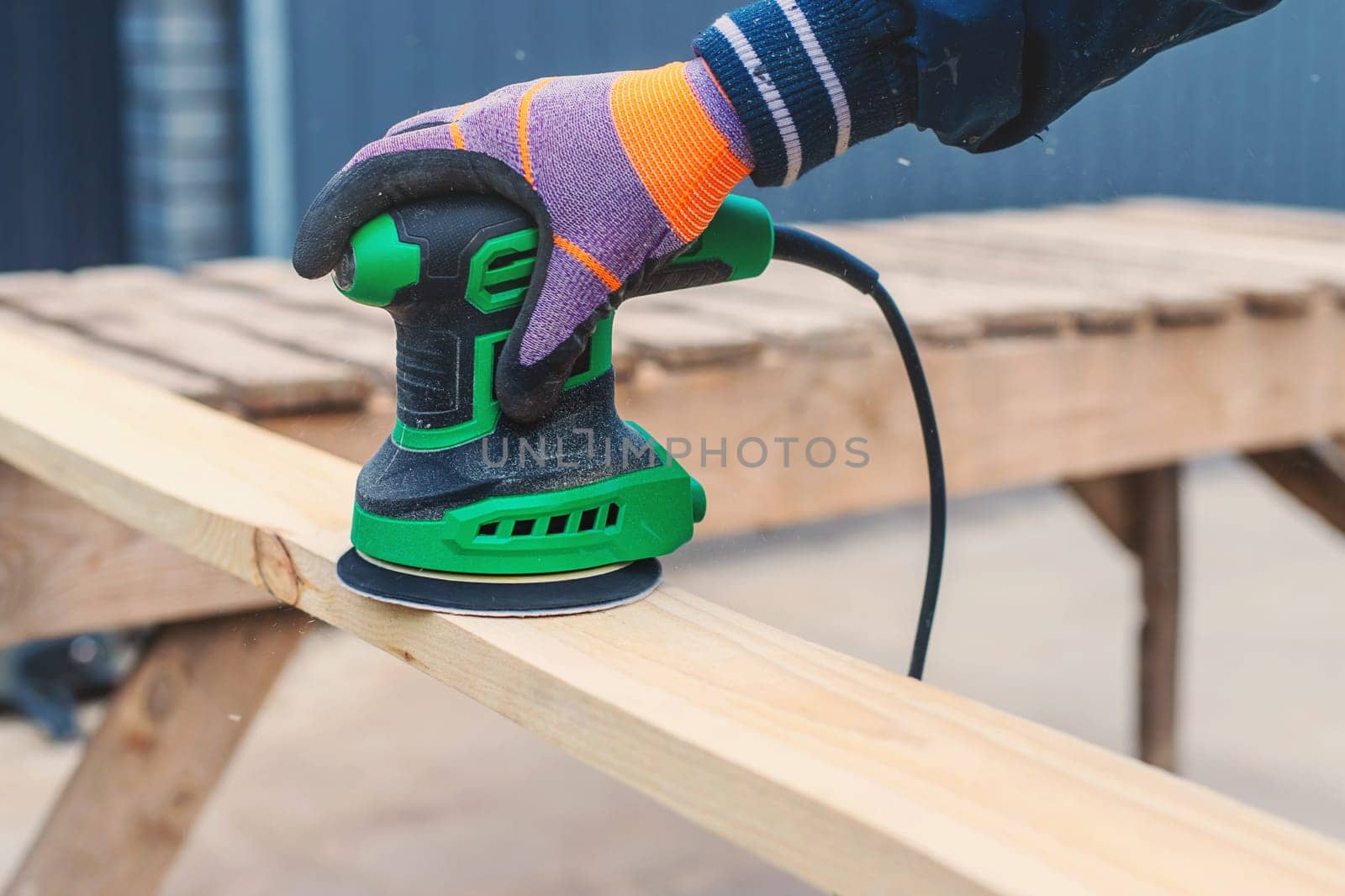 Man sanding wooden boards. Selective focus. People.
