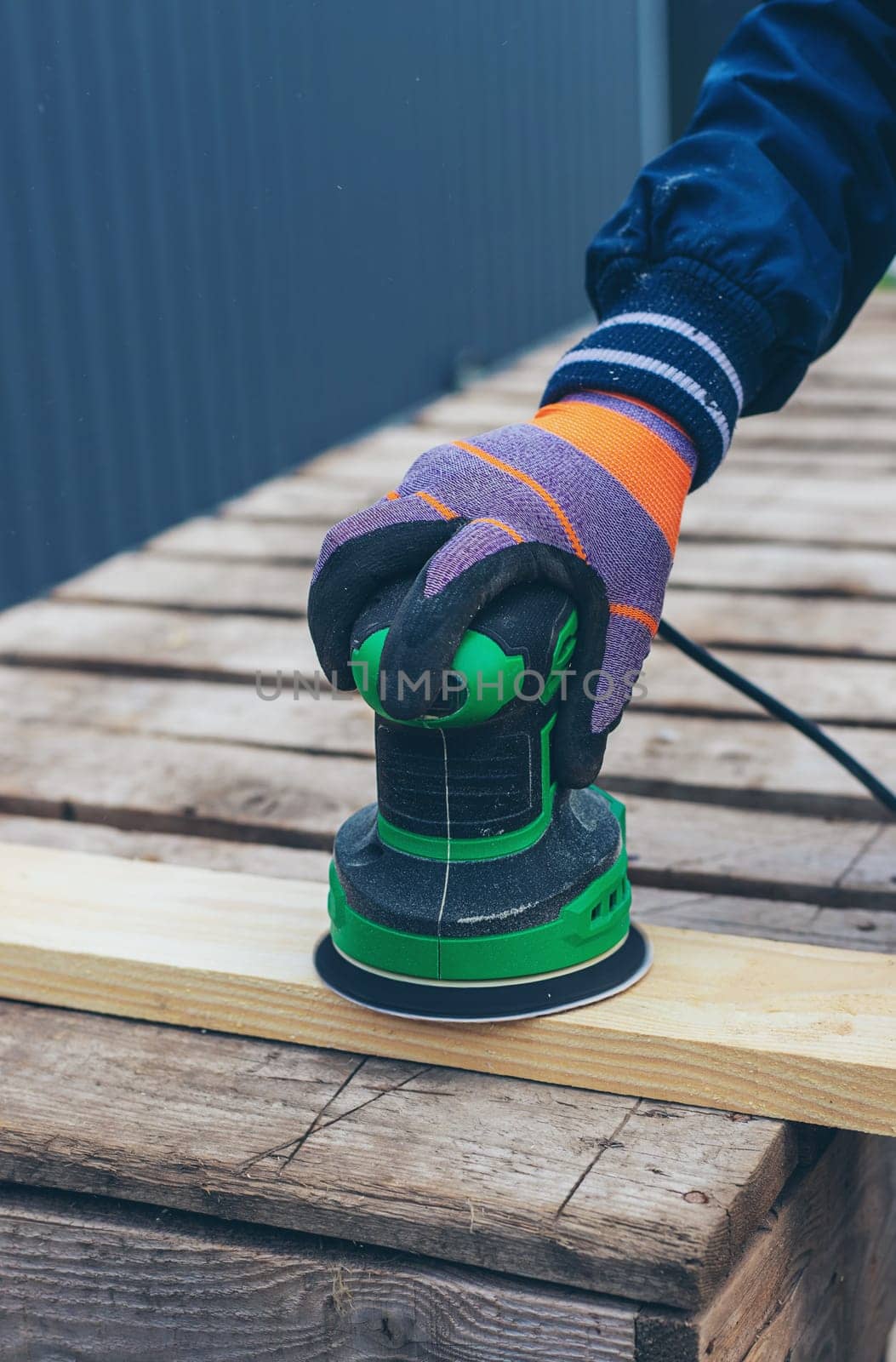 Man sanding wooden boards. Selective focus. People.