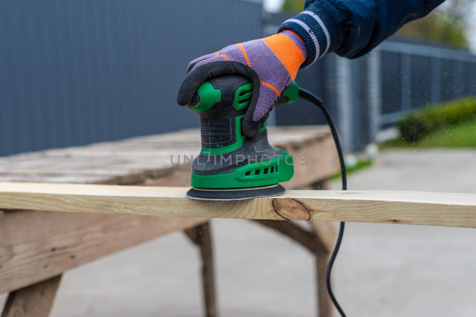 Man sanding wooden boards. Selective focus. People.