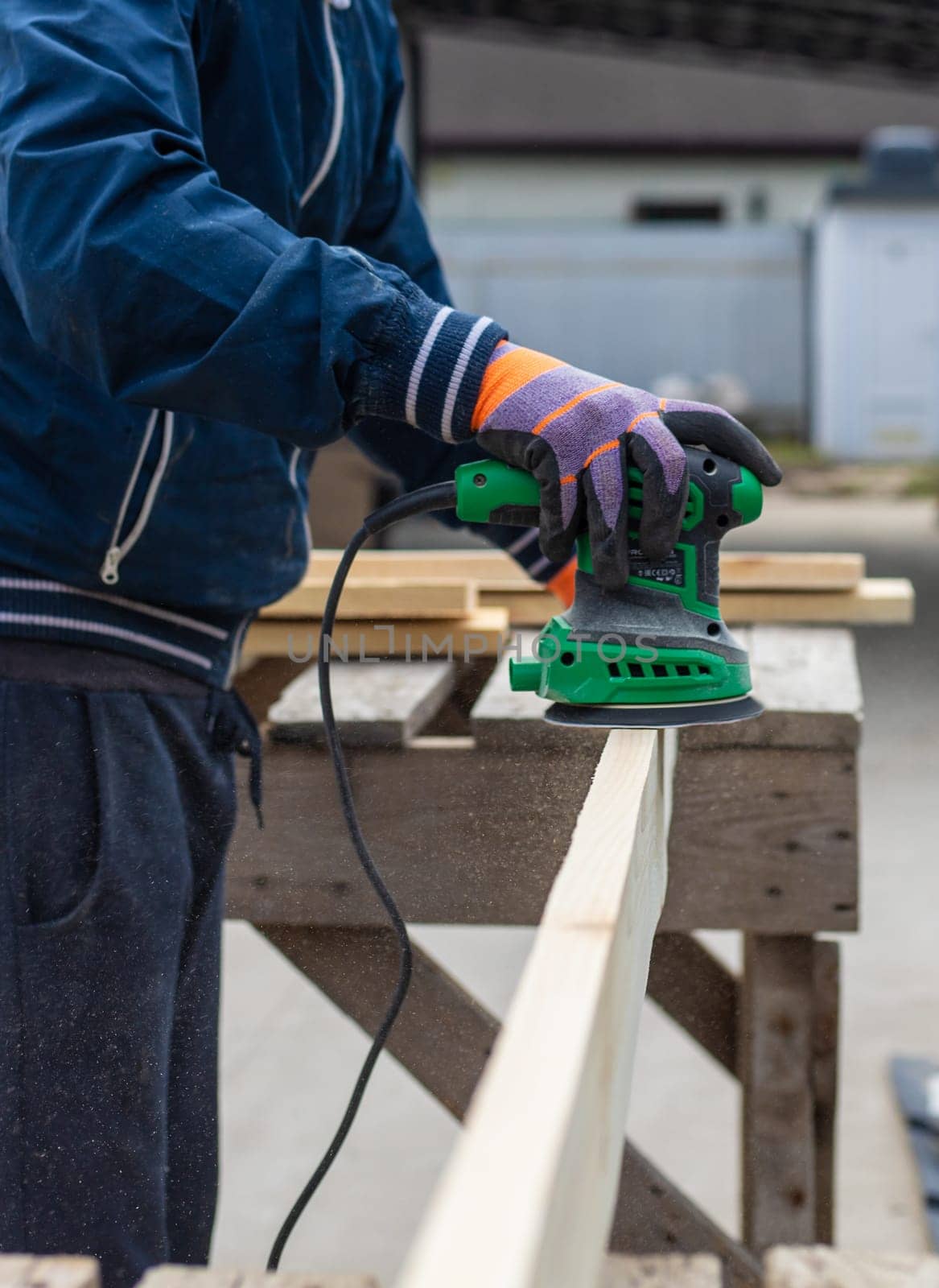 Man sanding wooden boards. Selective focus. People.