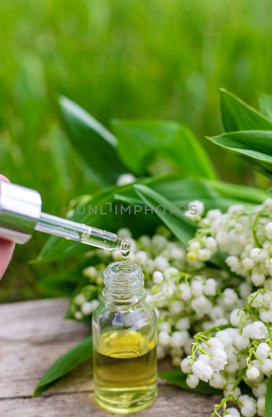 Lily of the valley extract in a bottle. Selective focus. nature.