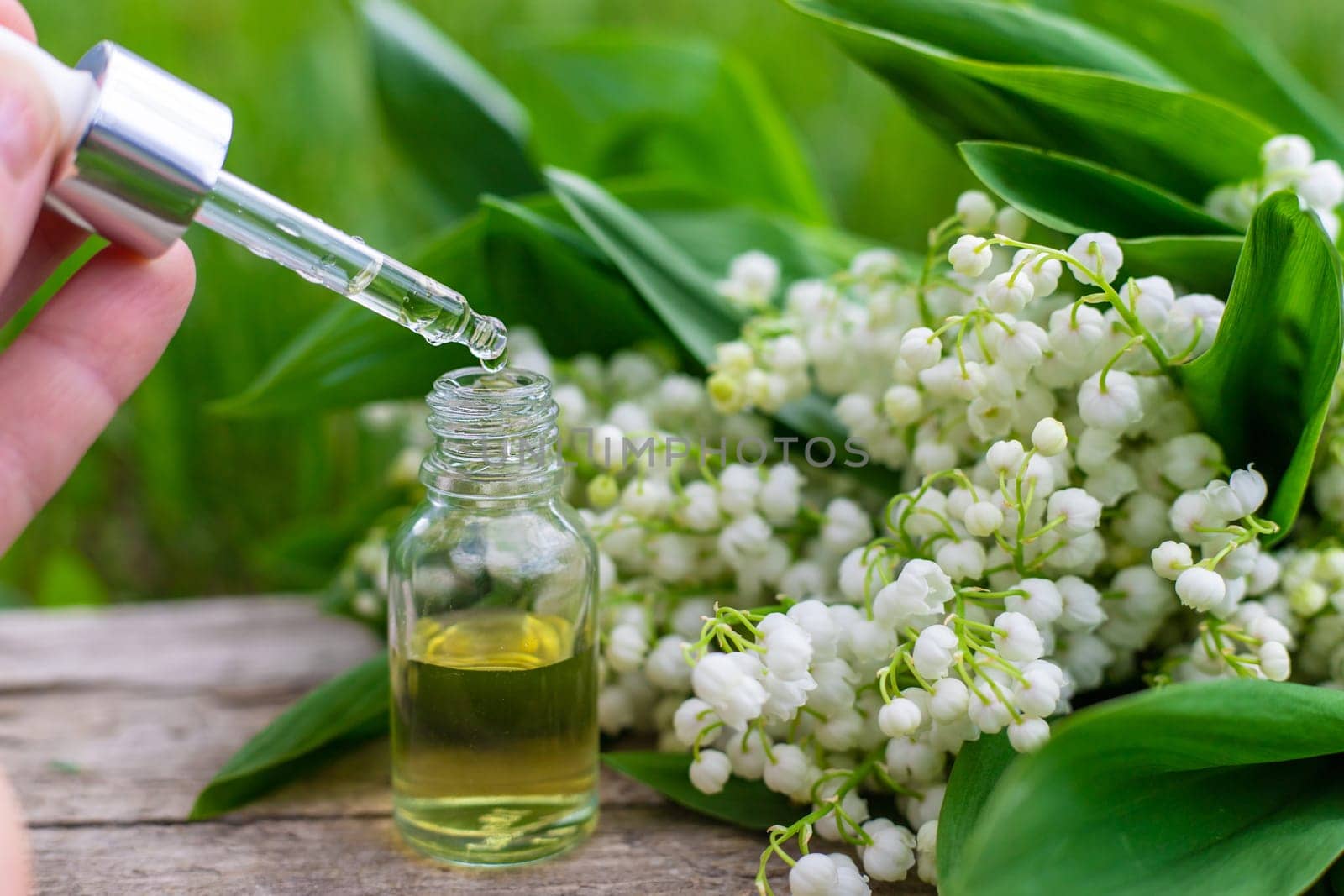 Lily of the valley extract in a bottle. Selective focus. nature.