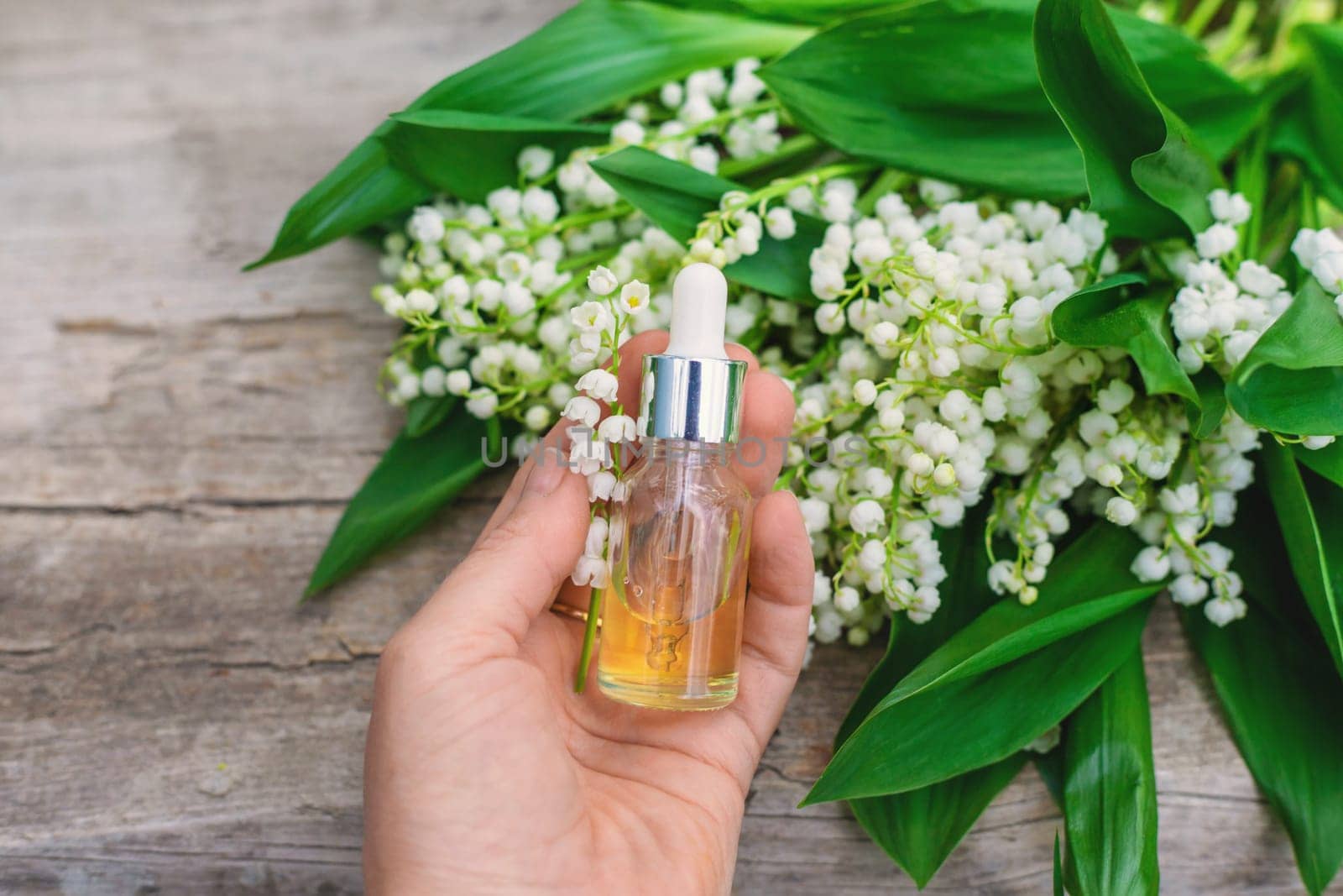 Lily of the valley extract in a bottle. Selective focus. nature.