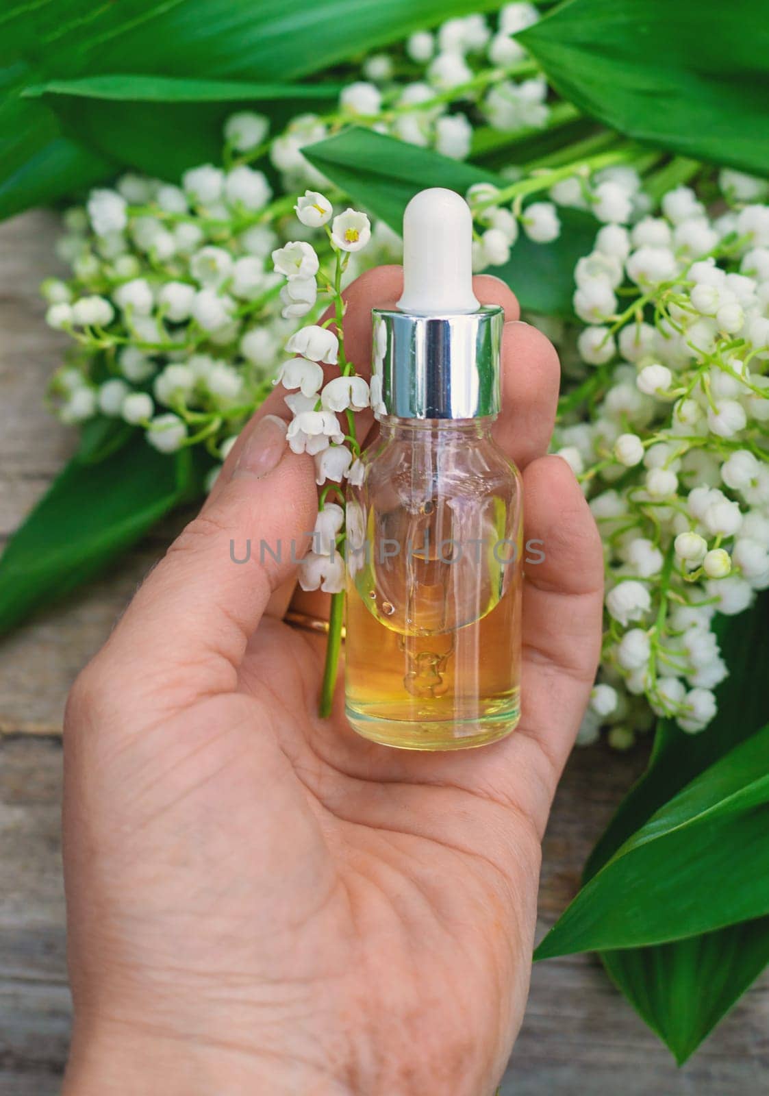 Lily of the valley extract in a bottle. Selective focus. nature.