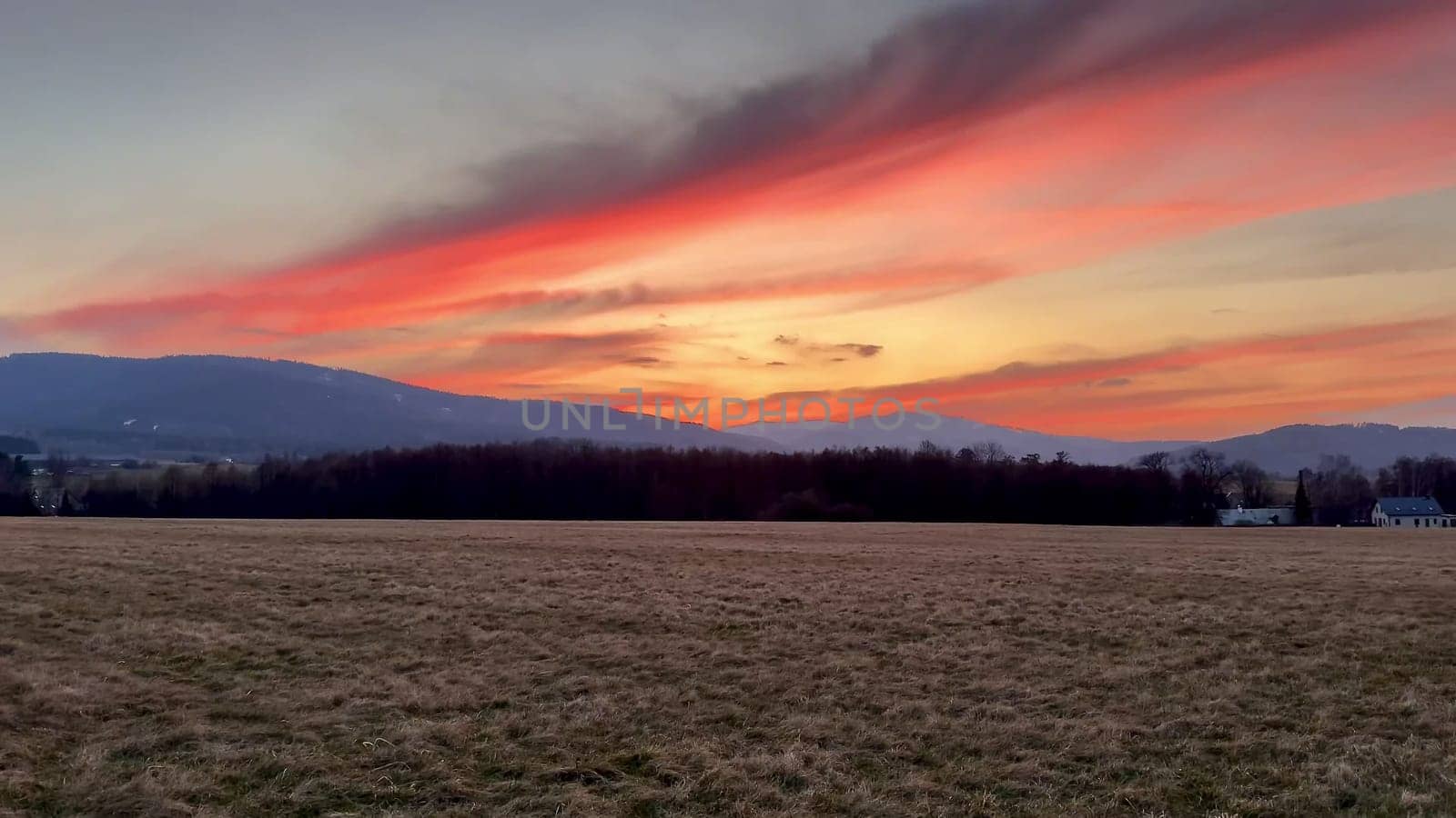 A breathtaking sunset vividly illuminating the expansive sky with vibrant hues over a serene landscape
