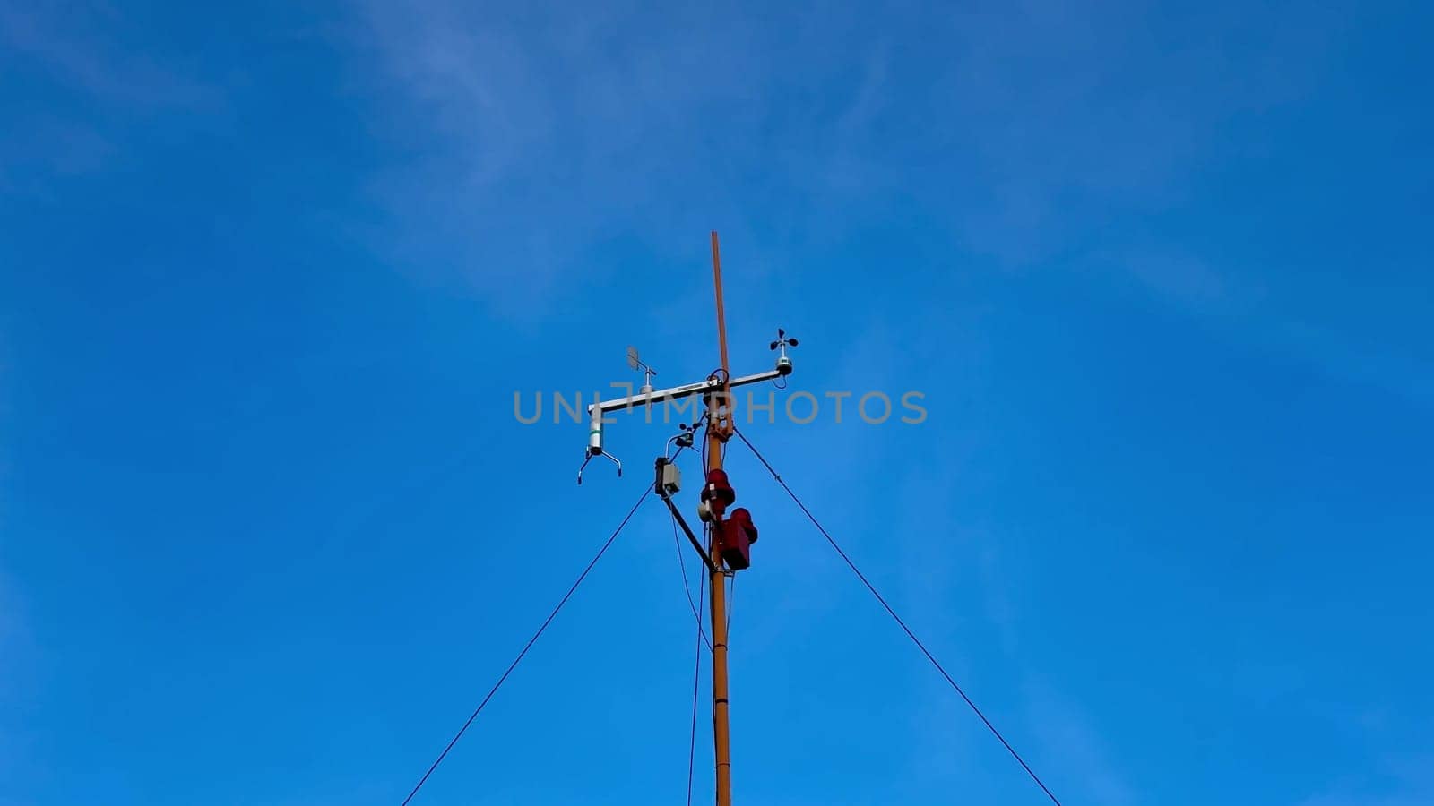 A highly skilled technician performs essential maintenance work on a utility pole against a bright blue sky