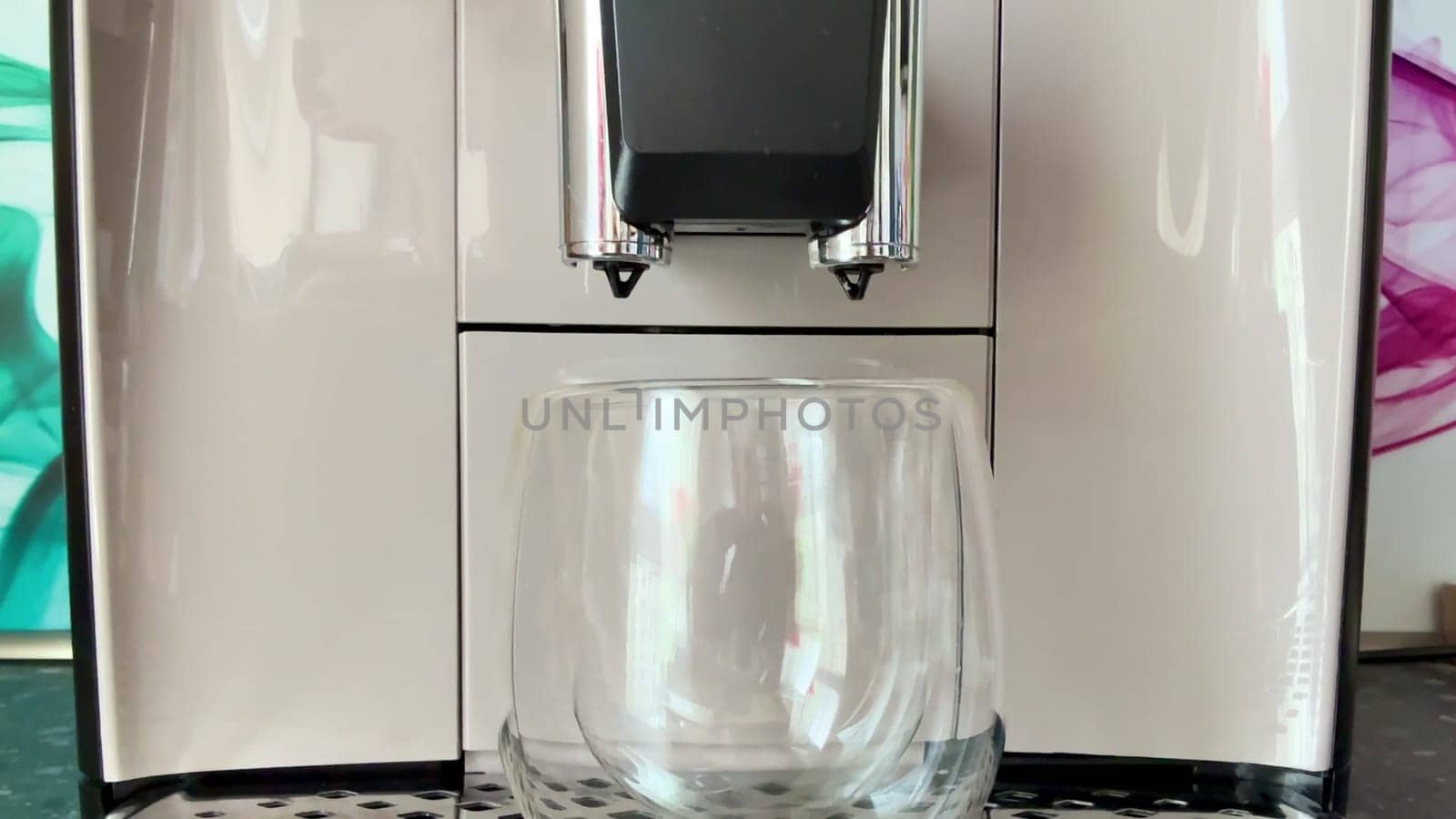 A sleek and modern coffee machine stands ready to brew your favorite beverage, complemented by a chic glass mug