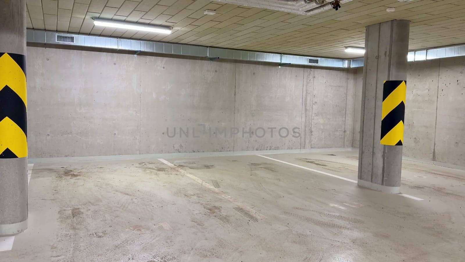 A clean, spacious parking garage with sturdy concrete walls and bold yellowblack safety markings for visibility