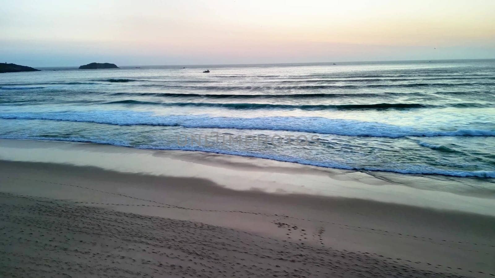 A tranquil view of gentle waves lapping against the shore at sunset, perfect for relaxation and nature themes.