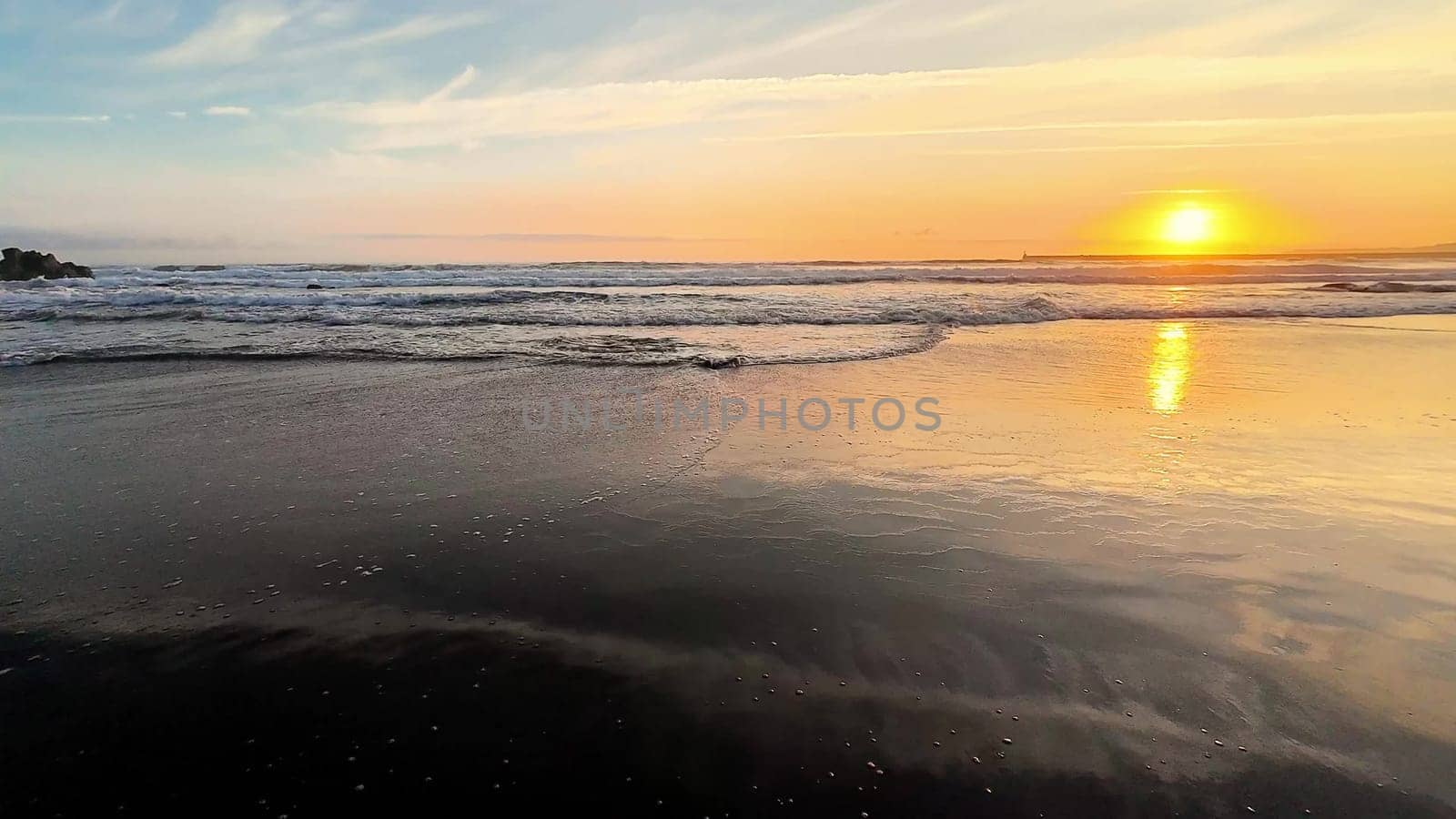 A breathtaking view of a stunning golden sunset beautifully reflecting on the tranquil ocean waves at the beach