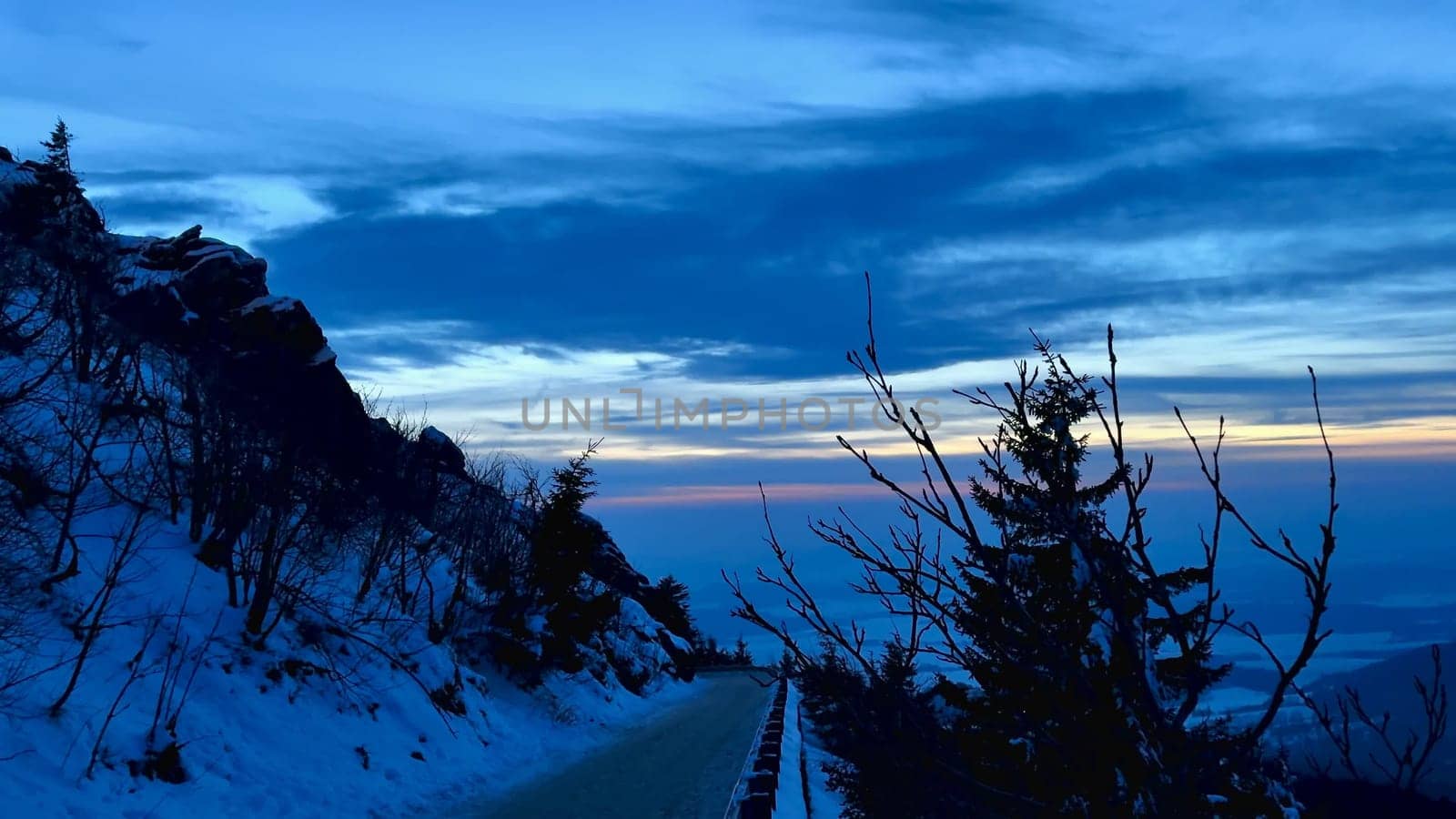 Evening view of snowy mountains and bright sky at sunset. High quality 4k footage