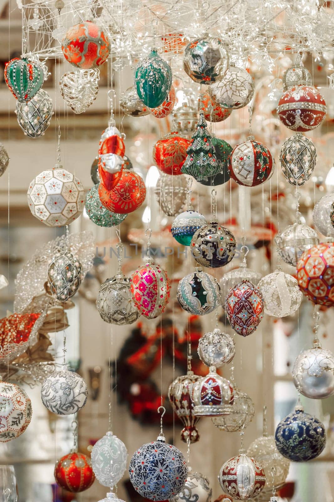 Showcase with glitter christmas balls hanging by the window case, festive decoration