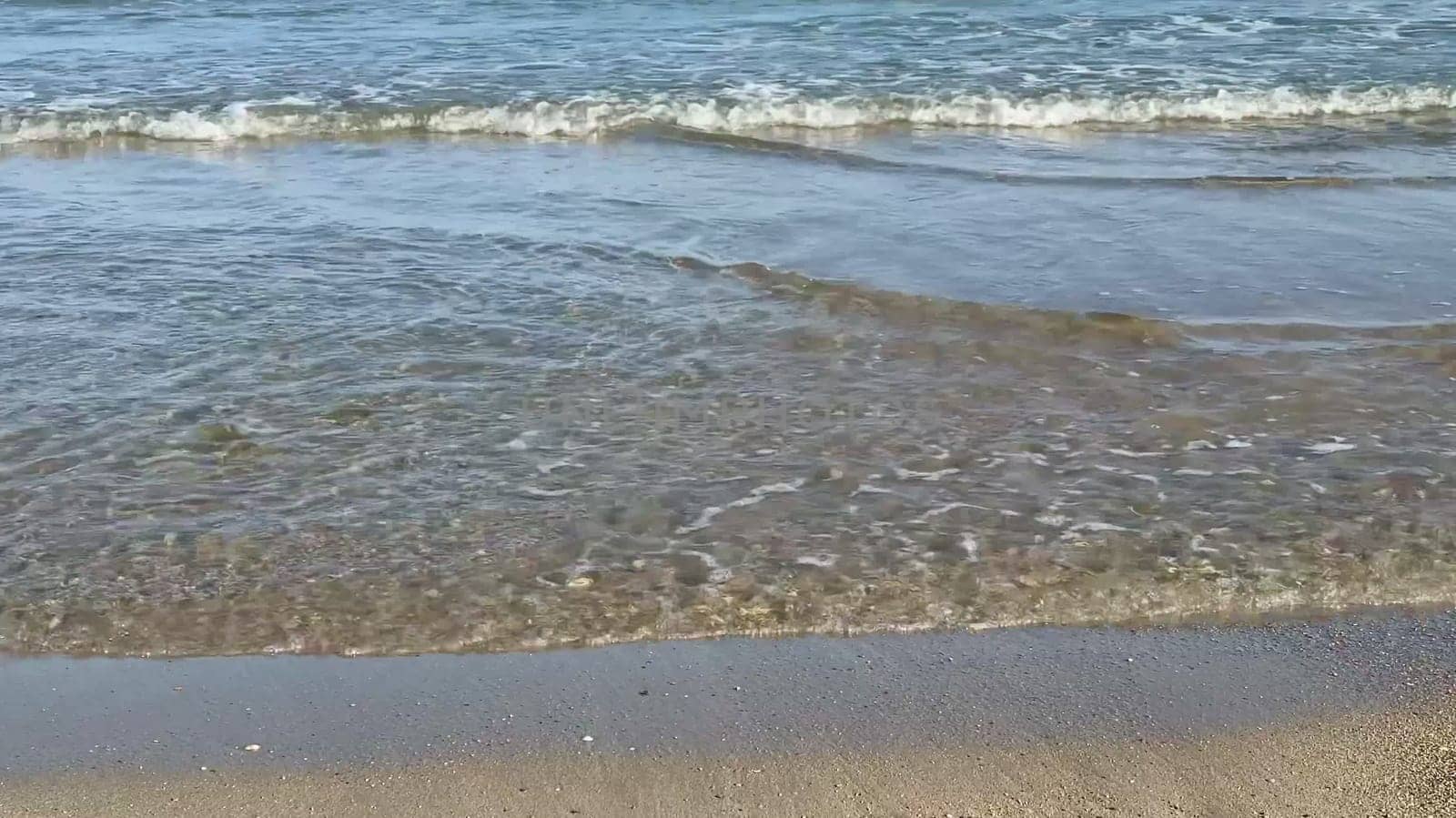 The beautiful ocean waves are gently caressing the soft sandy beach, creating a perfectly tranquil coastal scene