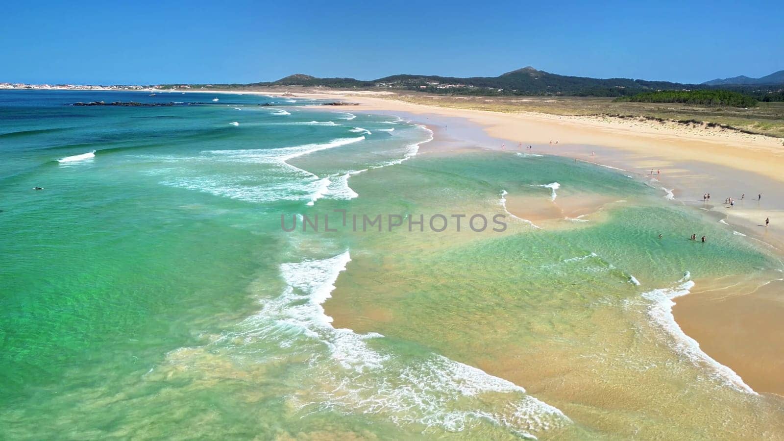 A breathtaking aerial shot showcasing a tranquil beach with crystalclear waters and gentle waves at the shore