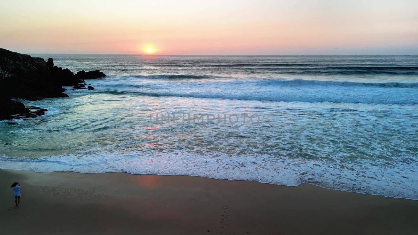A stunning view of the sunset beautifully reflecting on the calm waves of a tranquil and quiet beach