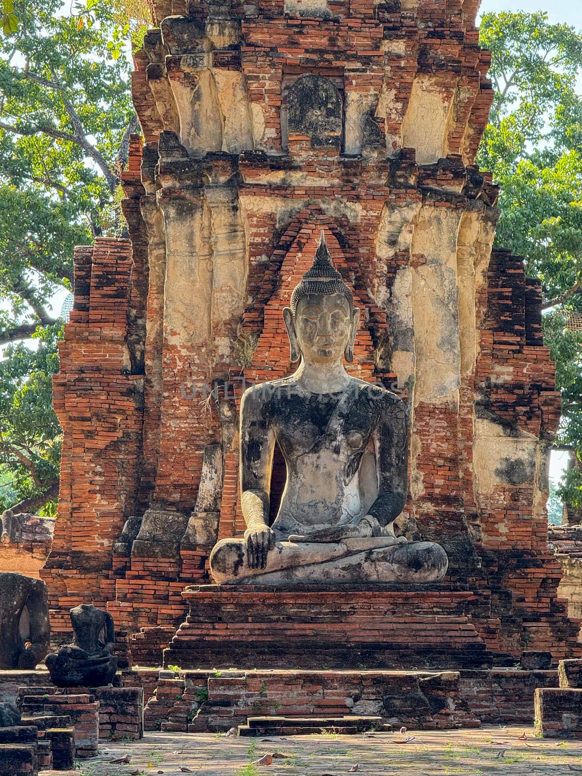 Ancient Buddha statues sitting peacefully in a sacred temple complex, Wat Maha That landmark representing faith and spirituality. Beautiful culture religious destination in Thailand.