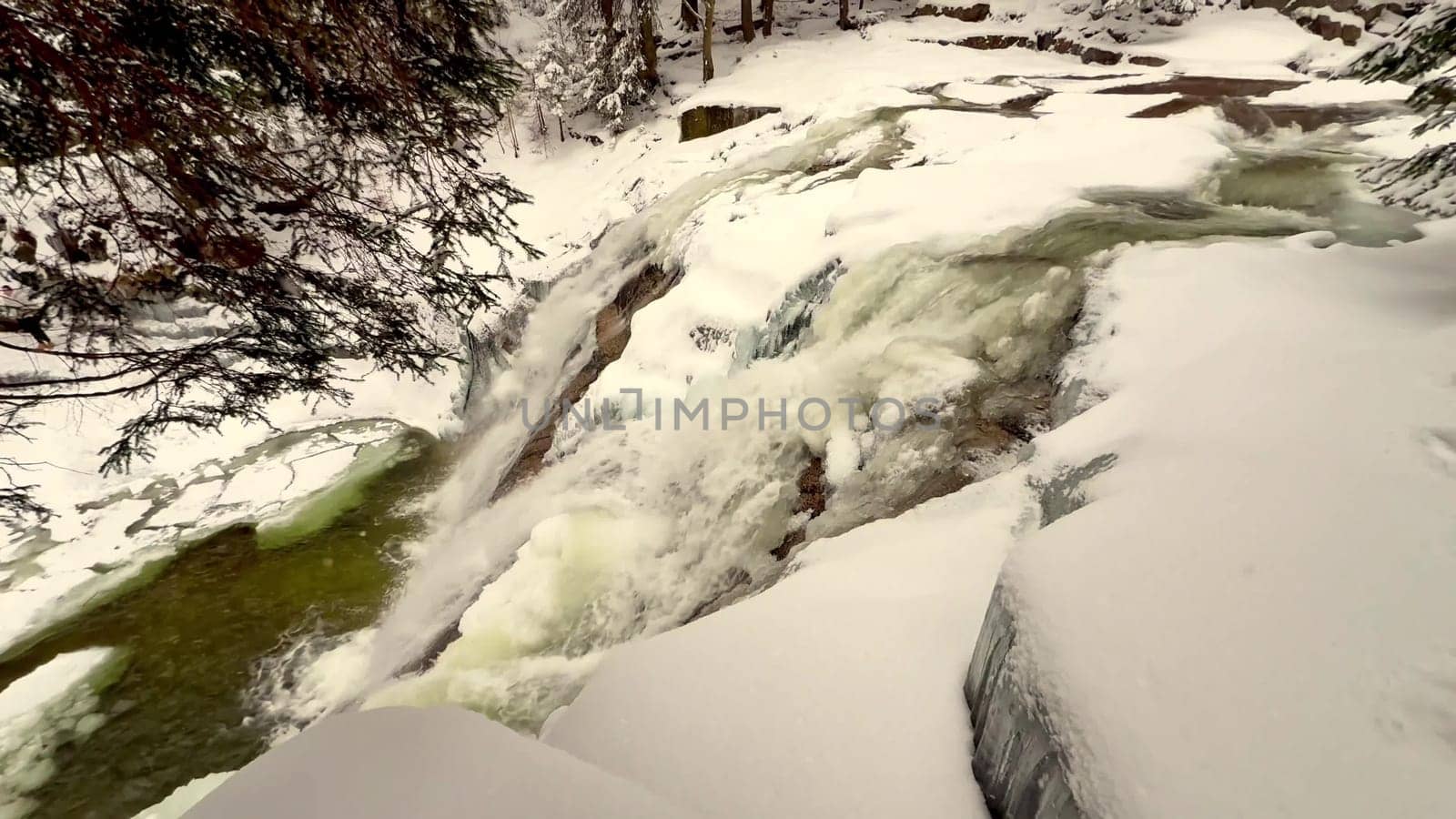 Frozen and snowy waterfall and winter forest. View from above. High quality 4k footage
