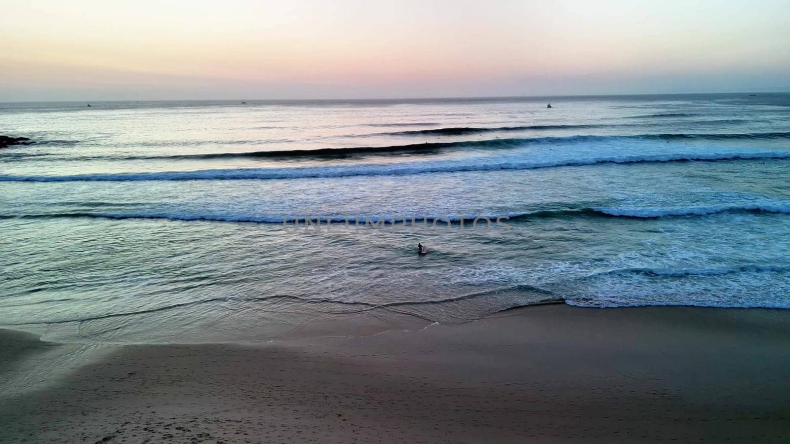 A stunning and picturesque sunset view over the gentle beach waves, creating a serene and calming atmosphere