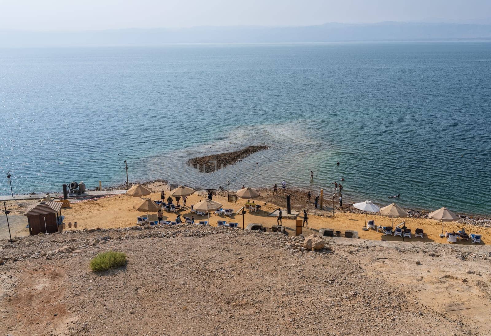 Dead Sea, Jordan - 8 November 2024: Tourists in the waters of Dead Sea by a beach in modern hotel
