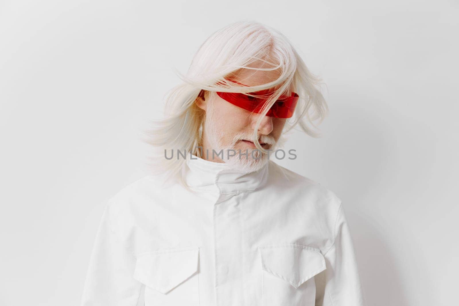 A fashionable elderly man with striking white hair and red tinted sunglasses, dressed in a white outfit against a clean white background, representing a blend of sophistication and contemporary style
