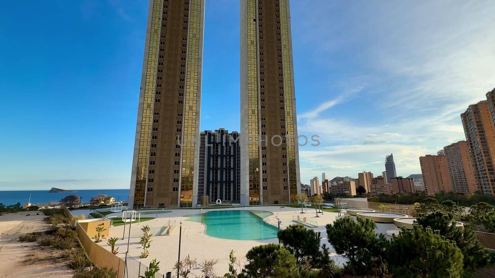 The stunning view features skyscrapers beside a shimmering pool, complemented by a picturesque ocean backdrop