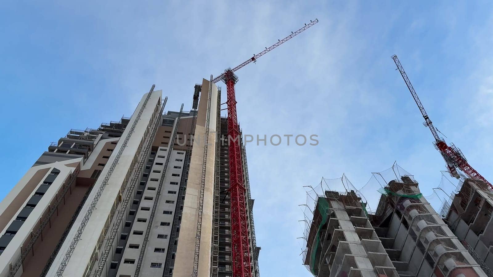 A dynamic and vivid view of a bustling construction site featuring tall buildings alongside active tower cranes