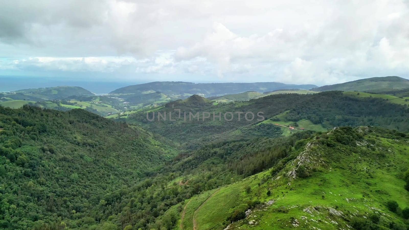The stunning view captures the lush green hills and expansive valleys beneath a beautifully dramatic sky
