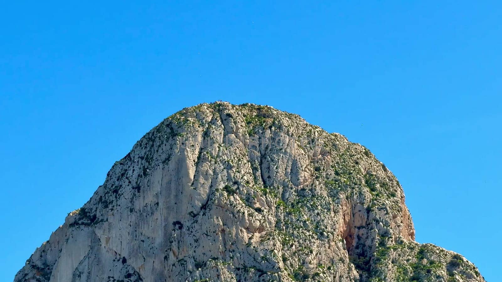 A breathtaking rocky peak majestically showcases the natural beauty that stands against a vibrant blue sky