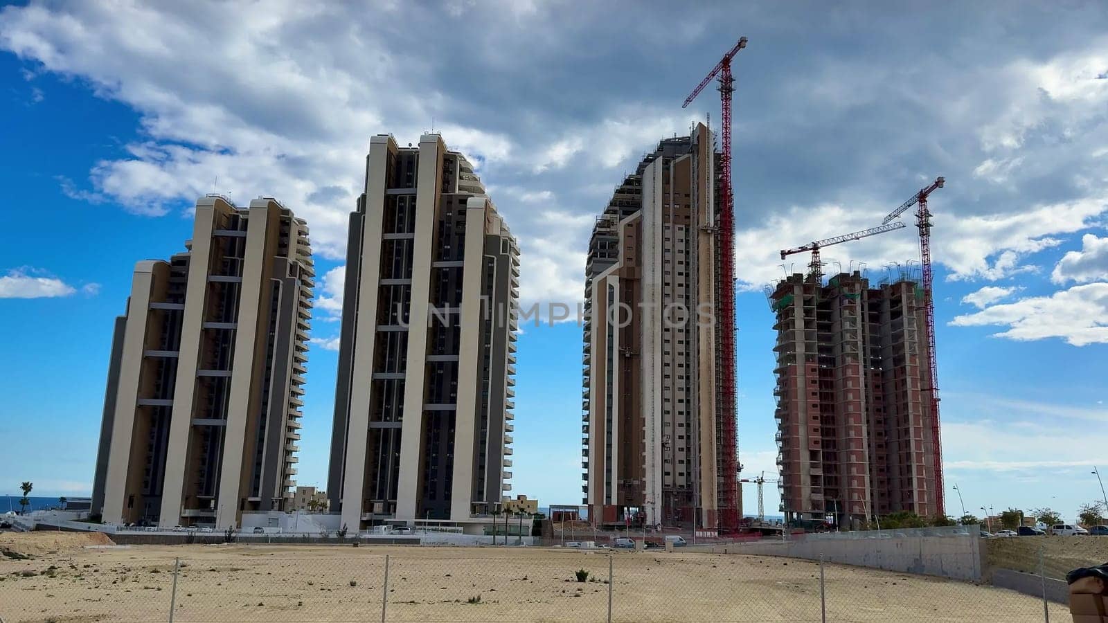 A dynamic and captivating view of towering skyscrapers currently under construction against a stunning blue sky