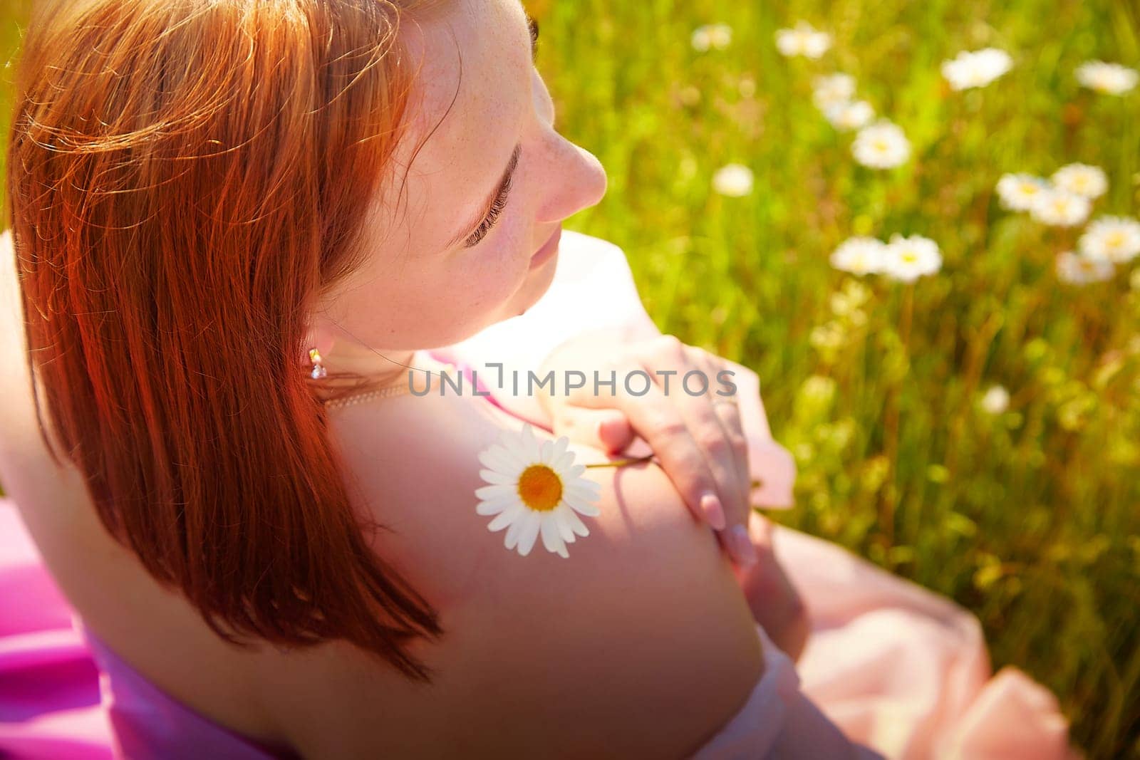 A young woman relaxes in a vibrant meadow, adorned with daisies, a single flower placed gently on her shoulder as she enjoys the warm sunlight.
