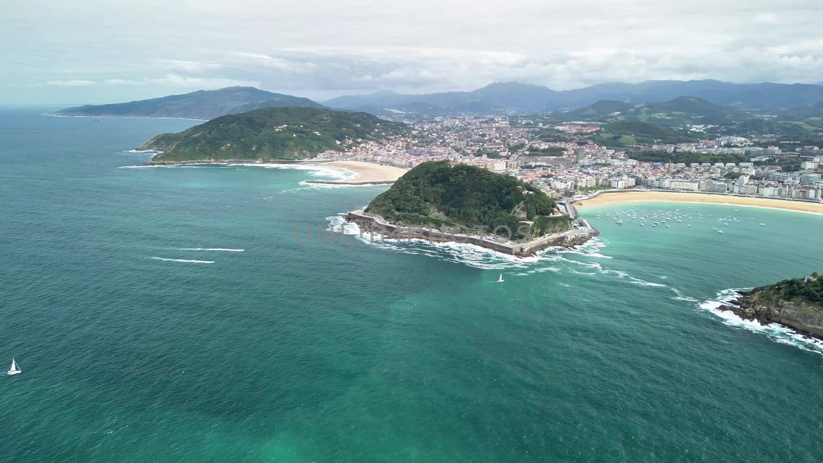 This breathtaking aerial shot beautifully showcases lush beaches and rocky islands along the stunning coast