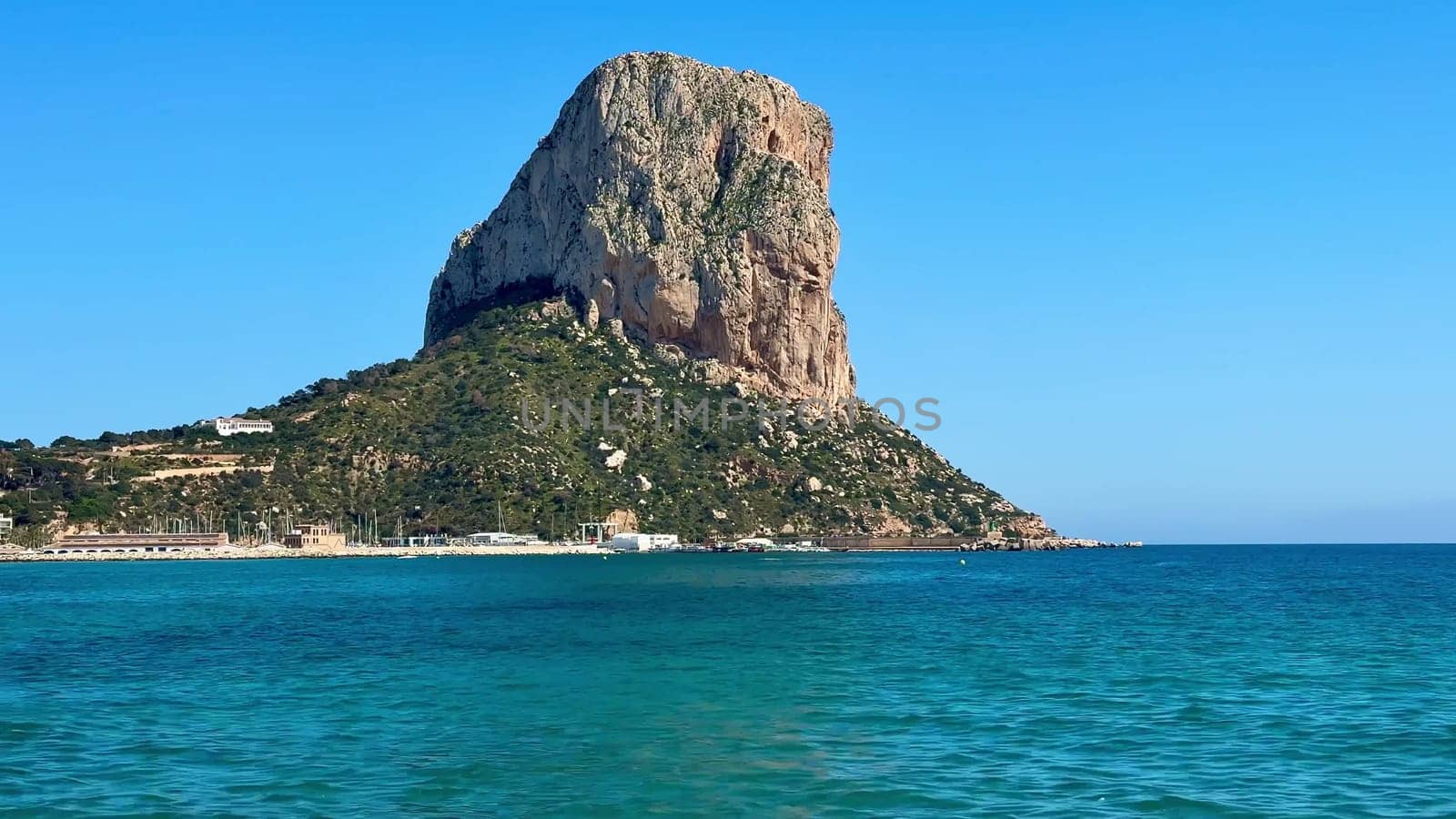 The breathtaking view features a towering rock formation majestically overlooking the crystalclear waters