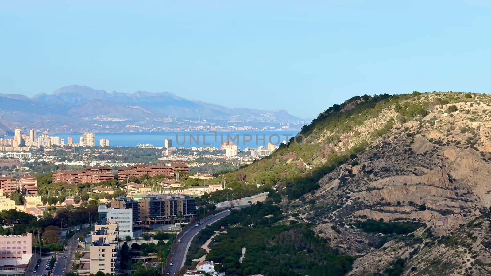 A captivating landscape that showcases a vibrant city nestled against majestic mountains and a serene sea backdrop