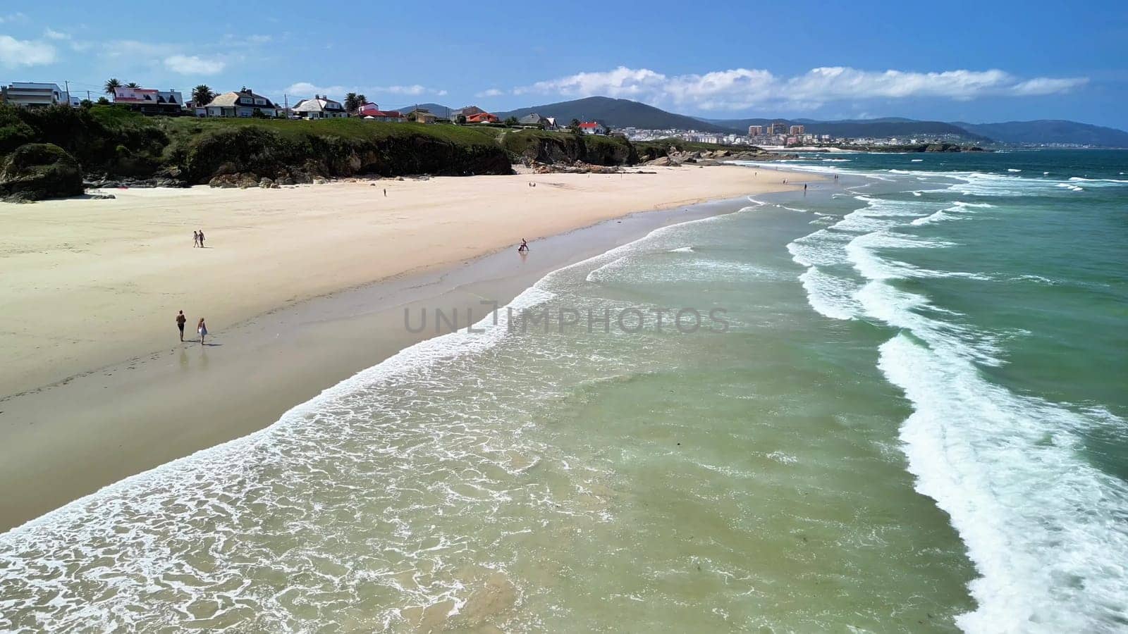 A stunning beach scene of golden sands, rolling waves, and endless blue skies, creating a perfect day