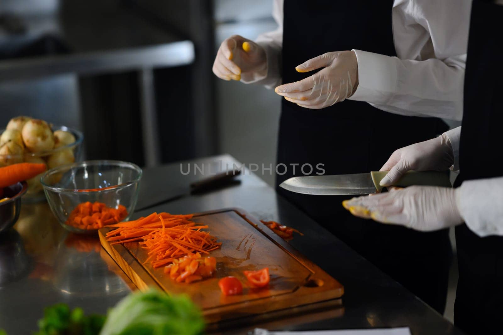 Cooking students slicing vegetables during a cooking class.