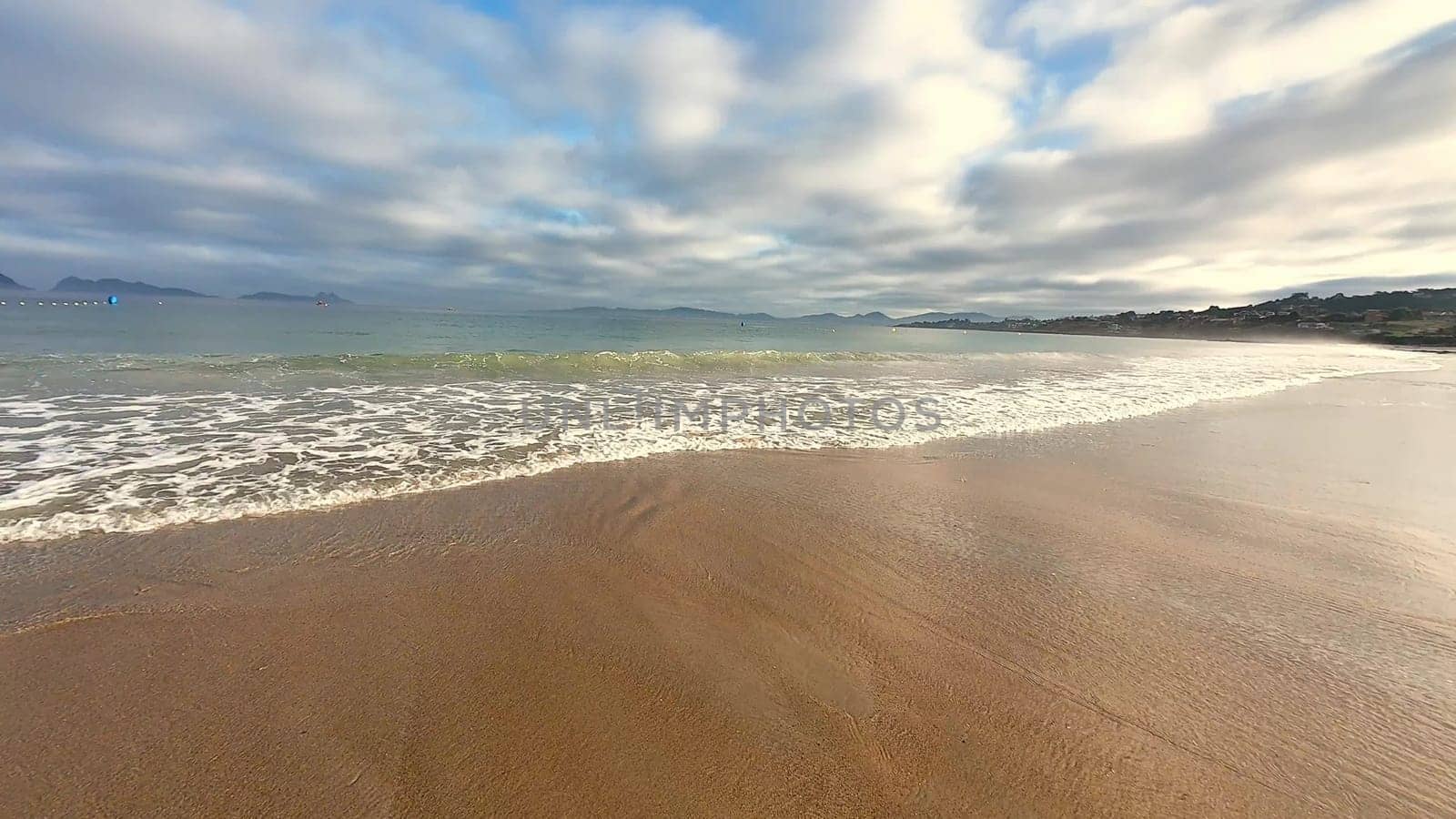 A beautifully tranquil beach scene is depicted, showcasing the gentle waves and a stunning cloudy sky above