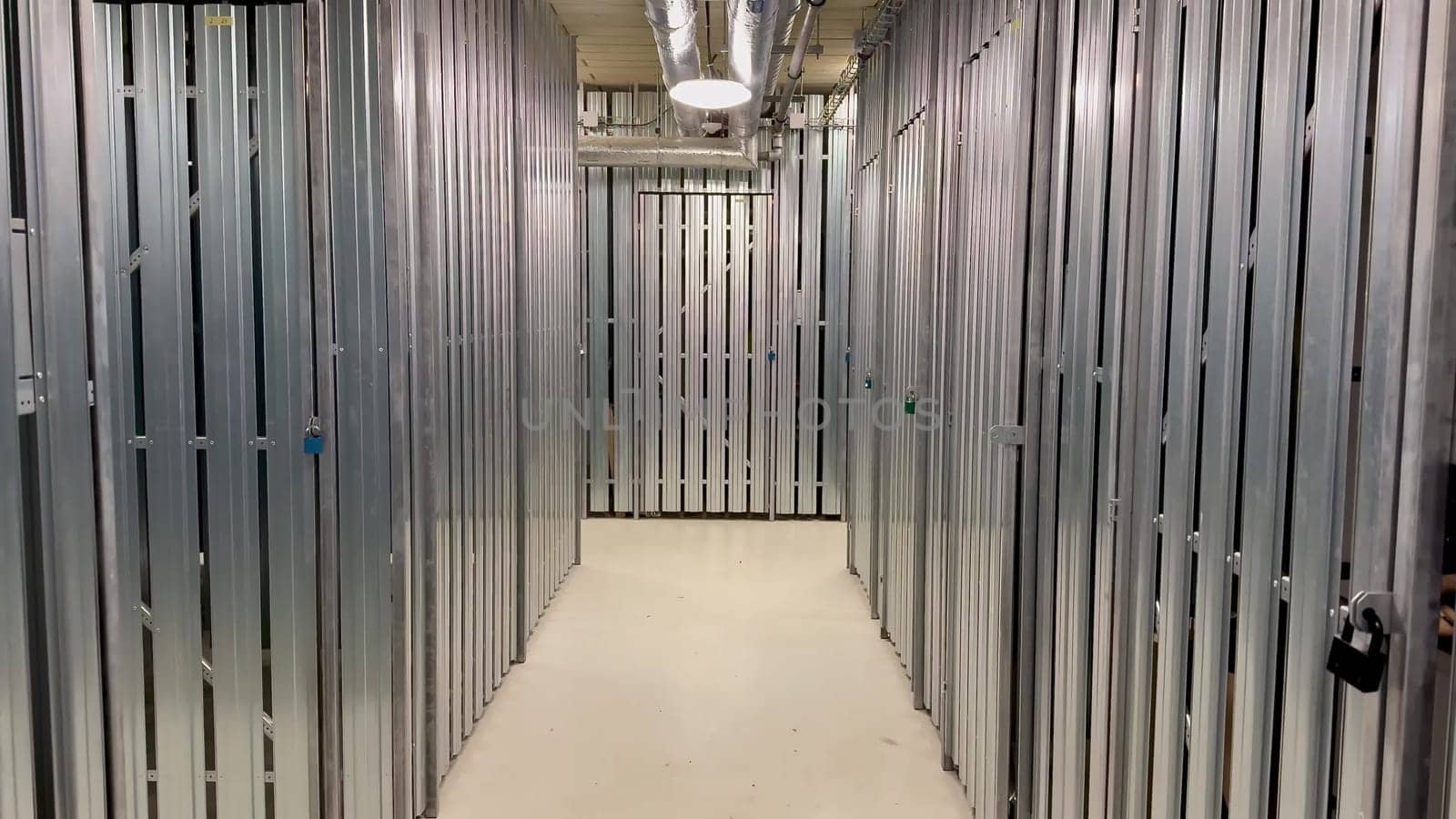 The interior view highlights a sleek and highly organized storage facility featuring numerous metal storage units