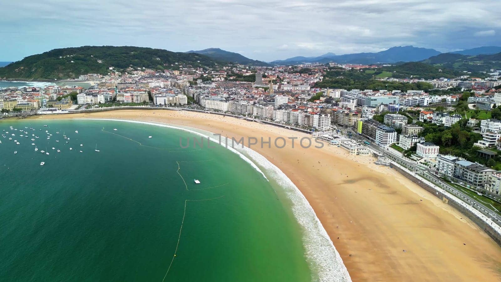Experience the stunning aerial view of a vibrant coastal city by the serene beach, combining nature and urban life
