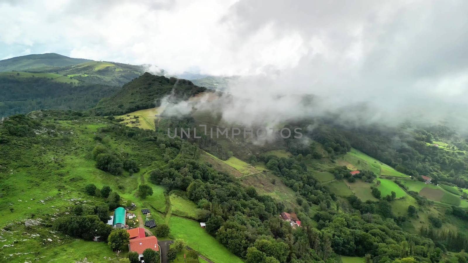 Experience breathtaking and stunning aerial views of the lush green hills nestled in a serene, mistcovered landscape