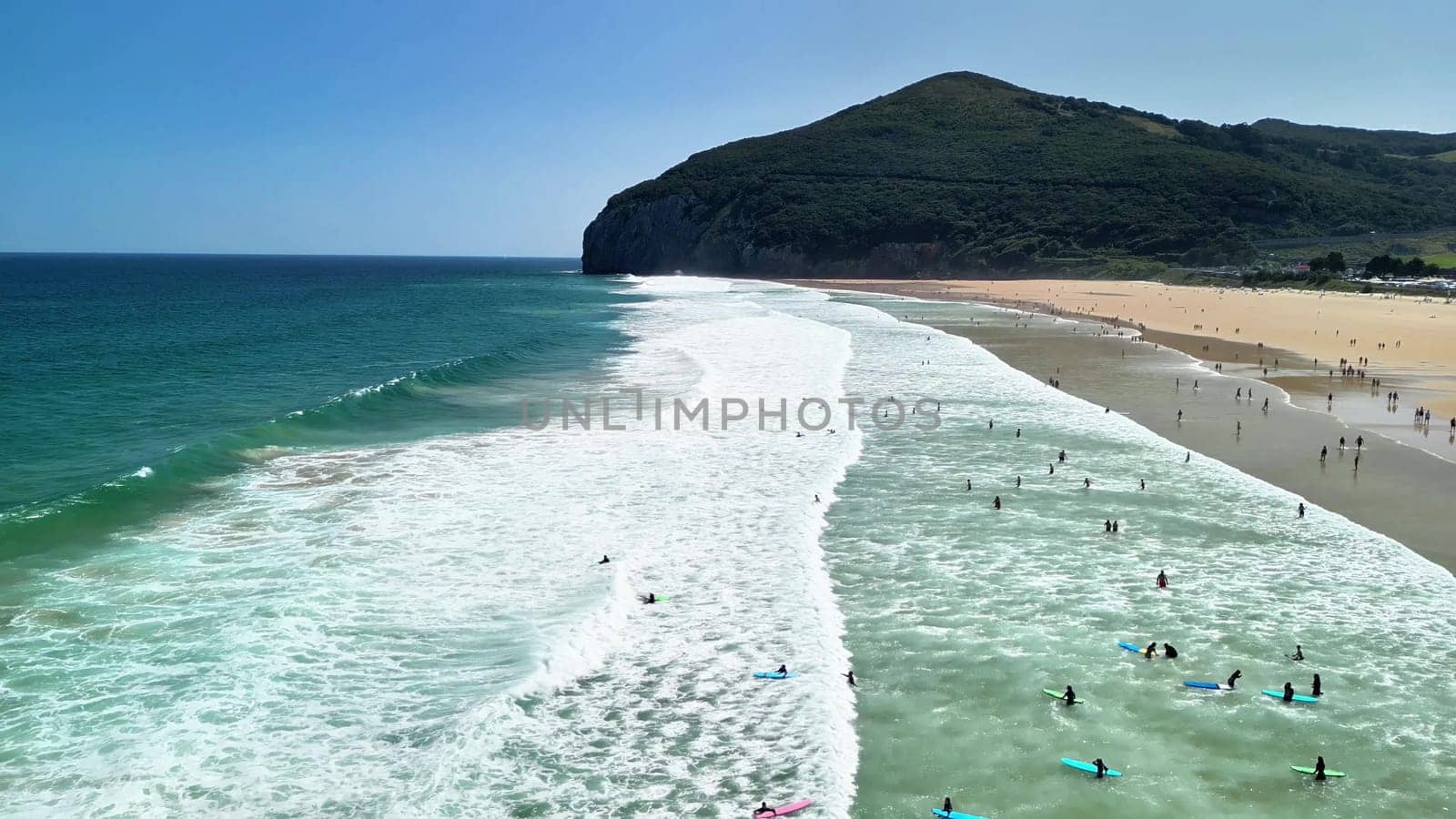 A beautiful beach with crashing waves, surfers, and a picturesque backdrop, perfect for summer vibes and relaxation