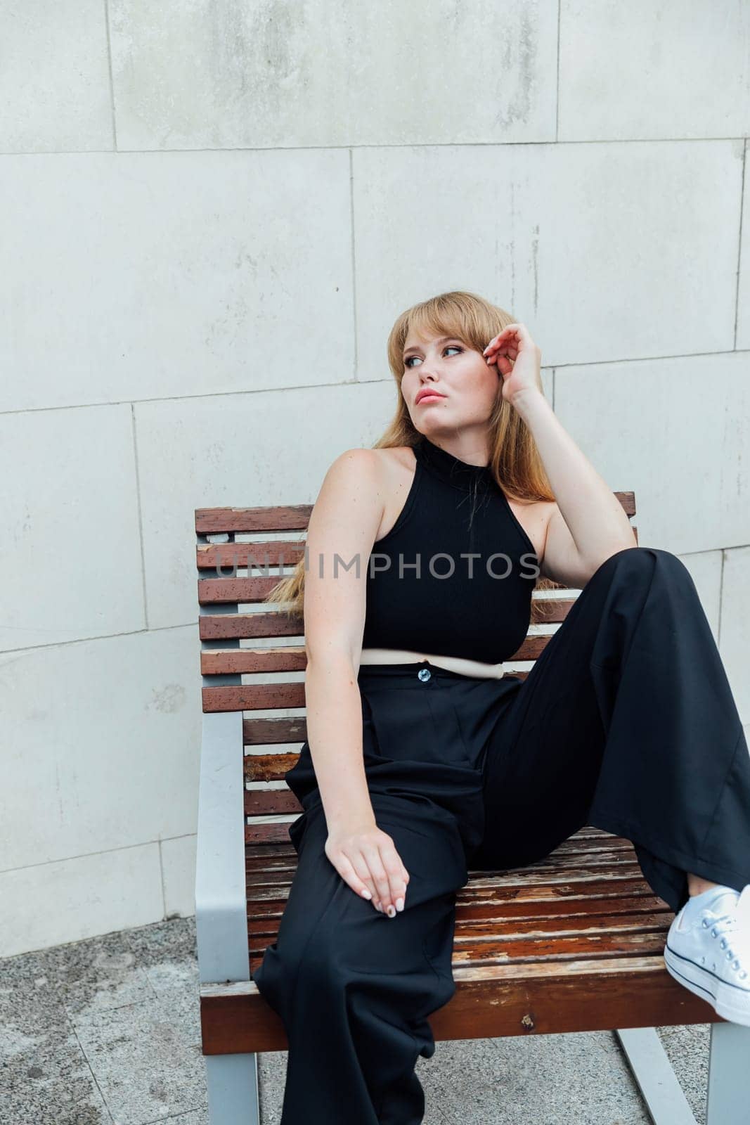 Beautiful female student in black street clothes walking around the city