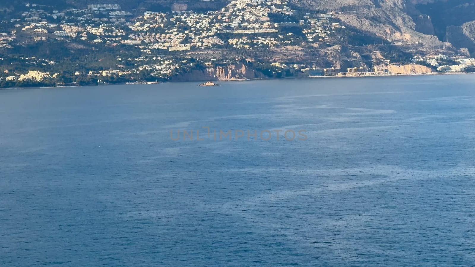 A breathtaking panorama of a coastal landscape featuring serene waters, hills, and picturesque homes.