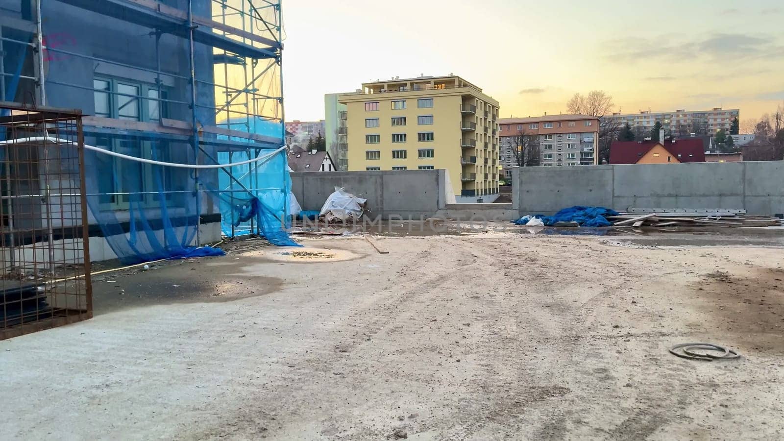 A construction site showcasing several unfinished buildings set against a beautiful, vibrant sunset sky backdrop