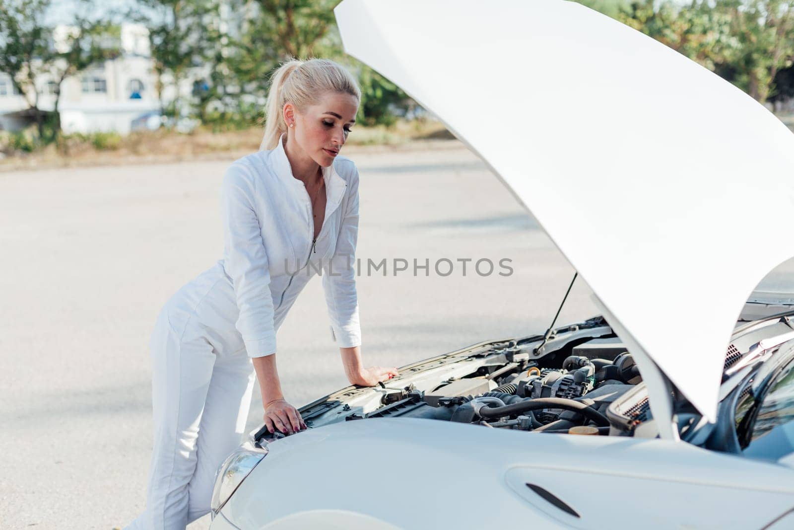Female car mechanic repairing car engine in garage