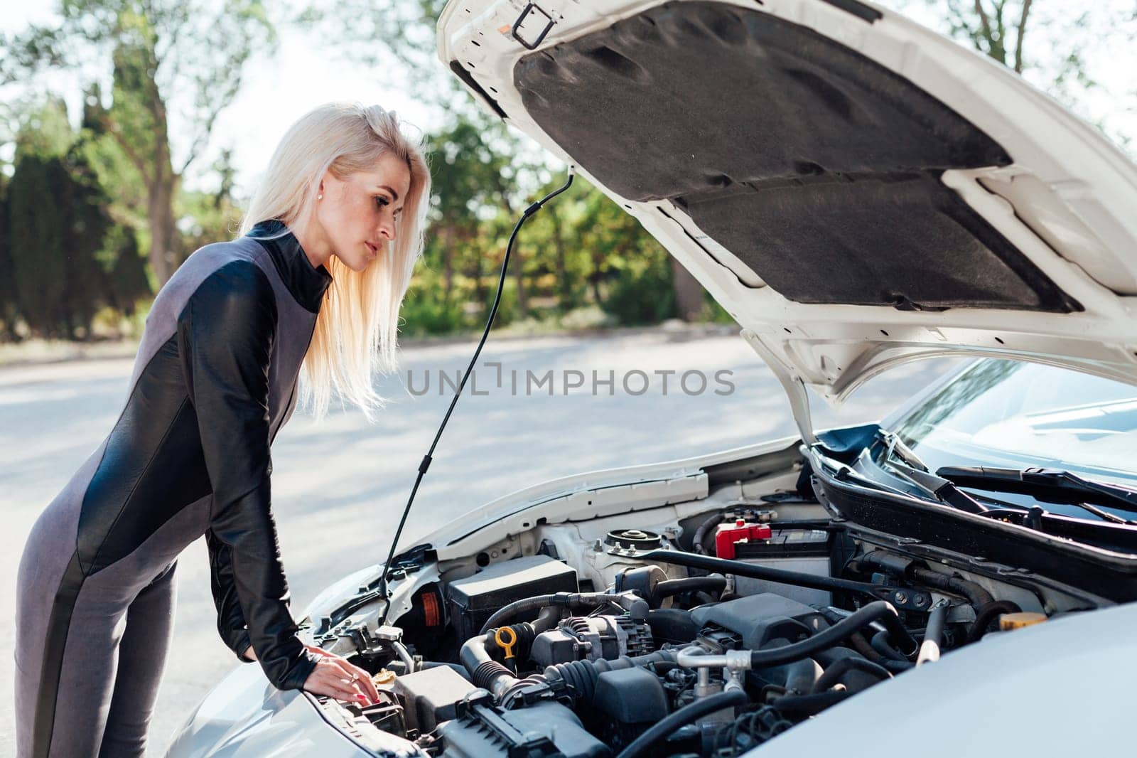 Female car mechanic repairing car engine in garage