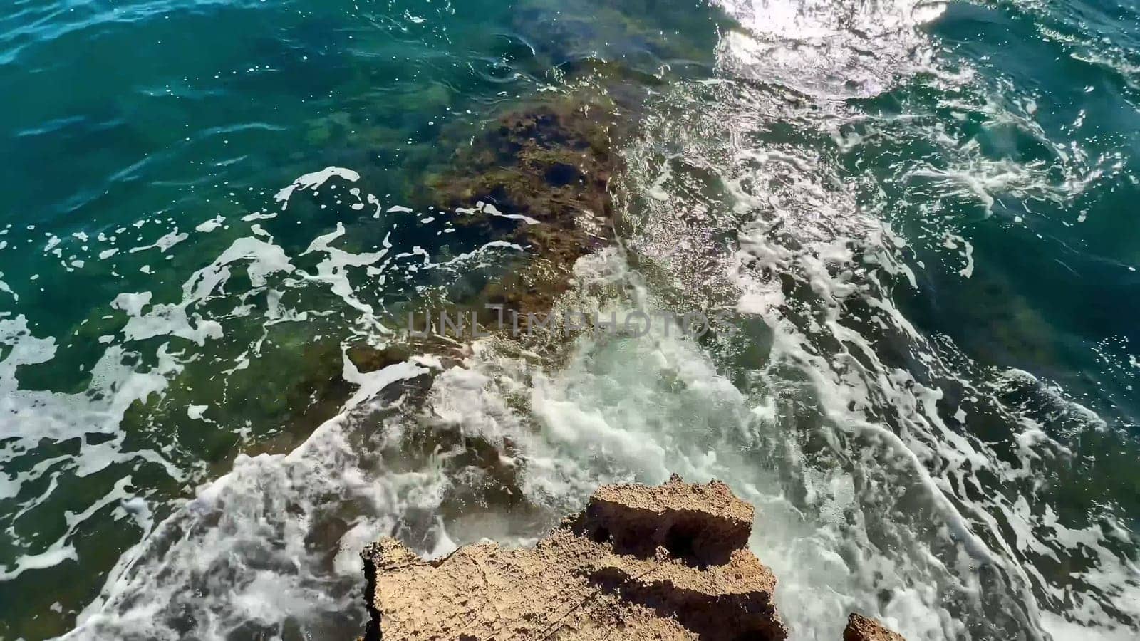 Dynamic ocean waves powerfully splash against rugged rocks, beautifully capturing the breathtaking natural beauty