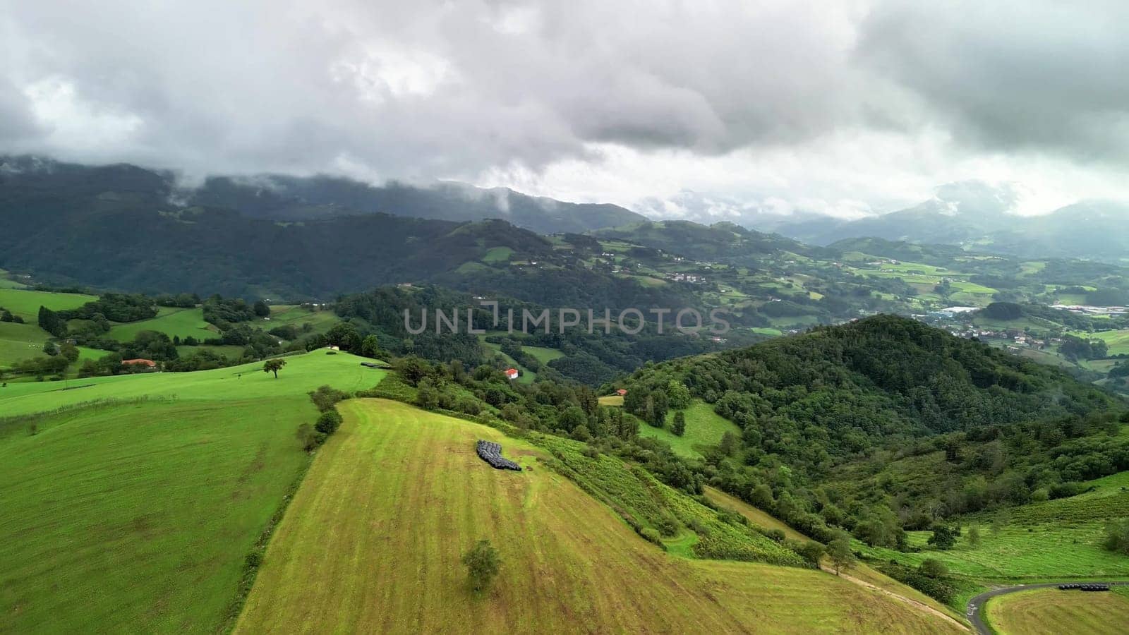 Experience the breathtaking aerial view of stunning landscapes showcasing green hills and valleys beneath cloudy skies