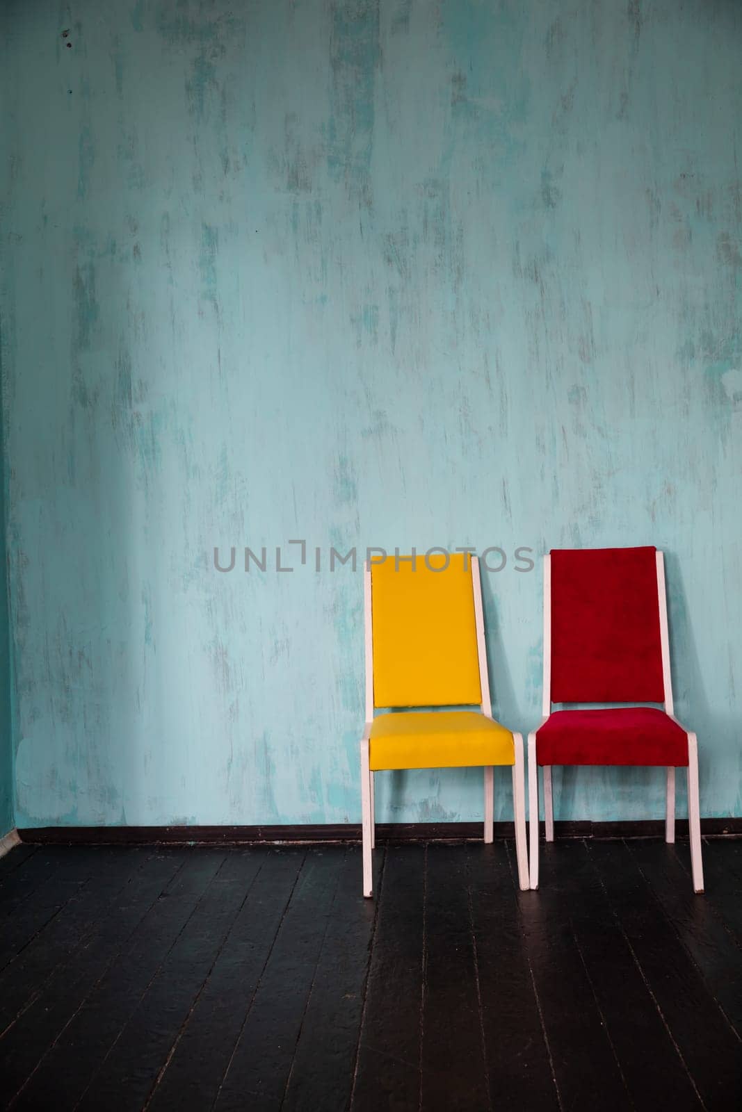 Two old chairs red and yellow in the interior of the blue room