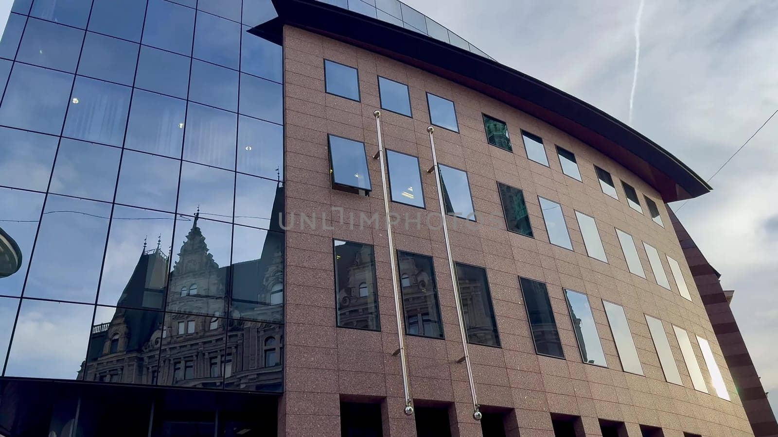 A modern commercial building design that prominently showcases a mixture of glass and stone elements