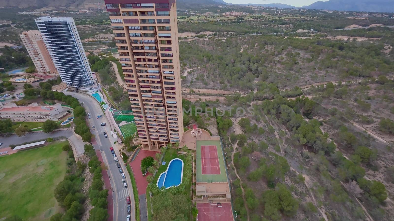 An aerial perspective beautifully showcasing luxury apartments that are surrounded by lush landscapes and scenic hills